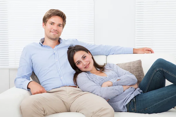 Szczęśliwa para relaksujący na kanapie — Zdjęcie stockowe