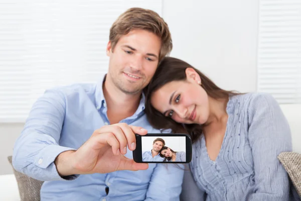 Casal tomando auto retrato com smartphone — Fotografia de Stock