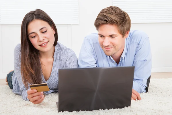 Casal usando laptop e cartão de crédito — Fotografia de Stock