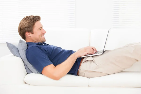 Smiling Man Using Laptop On Sofa — Stock Photo, Image