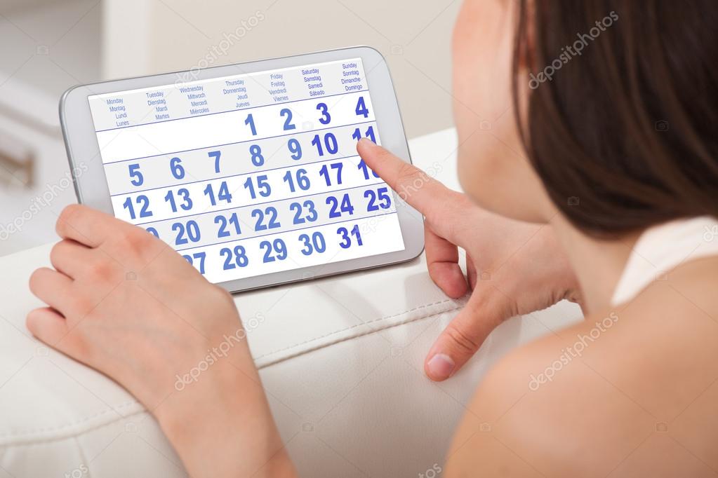 Woman Using Calendar On Digital Tablet