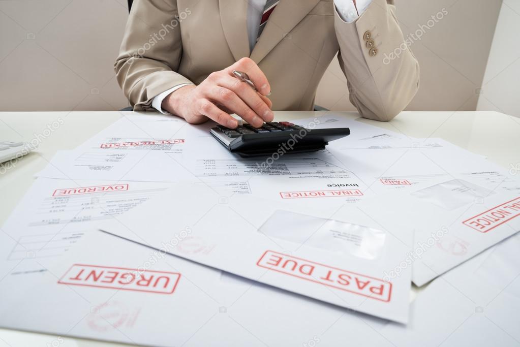 Businessman With Calculator And Bills