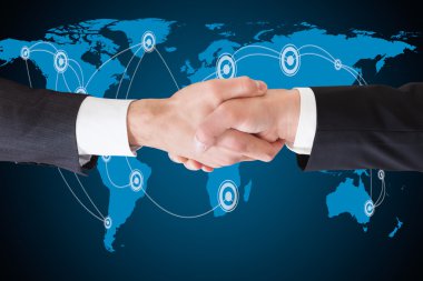 Businessmen Shaking Hands Against World Map clipart