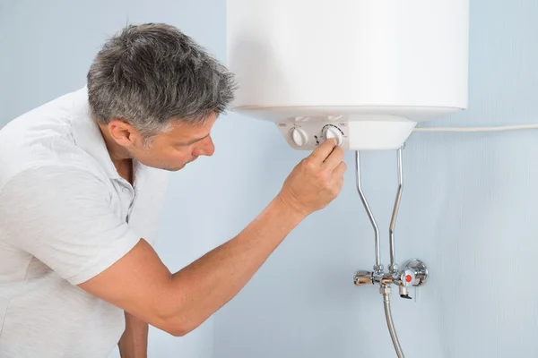 Homem ajustando a temperatura da caldeira elétrica — Fotografia de Stock