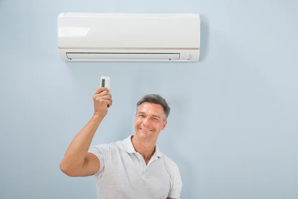 Hombre usando aire acondicionado — Foto de Stock