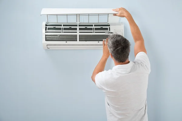 Hombre limpieza sistema de aire acondicionado — Foto de Stock