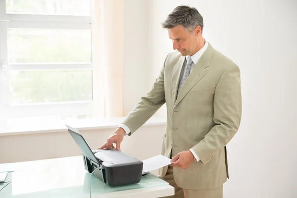 Homme d'affaires utilisant une machine à photocopier — Photo