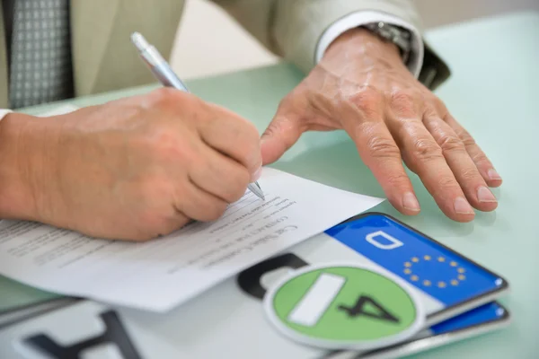 Geschäftsmann füllt Auto-Kaufvertrag — Stockfoto