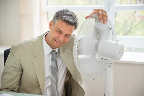 Empresário sentado perto do ventilador — Fotografia de Stock