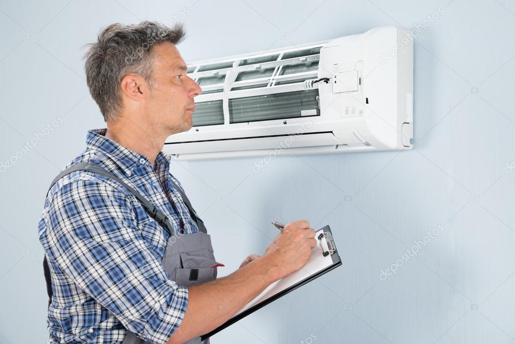 Technician Looking At Air Conditioner Stock Photo by ©AndreyPopov 72077933