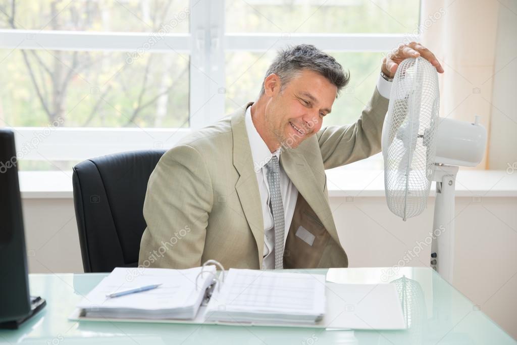 Businessman Sitting Near Fan