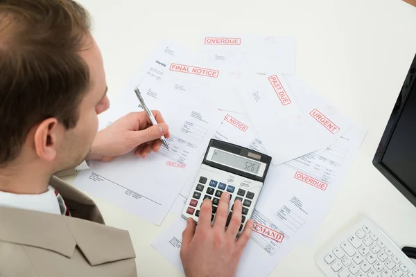 Geschäftsmann berechnet unbezahlte Rechnungen — Stockfoto