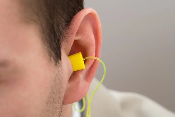 Yellow Earplug Into Ear — Stock Photo, Image