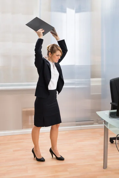 Mujer de negocios en furia lanzando portátil — Foto de Stock