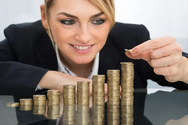 Mujer de negocios que pone monedas — Foto de Stock