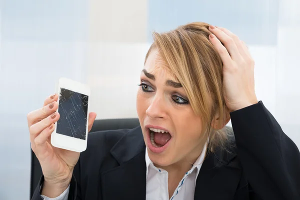 Empresária segurando smartphone quebrado — Fotografia de Stock