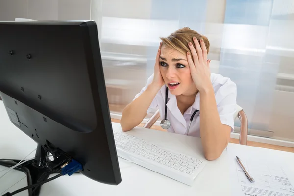Orolig läkare tittar på en dator — Stockfoto