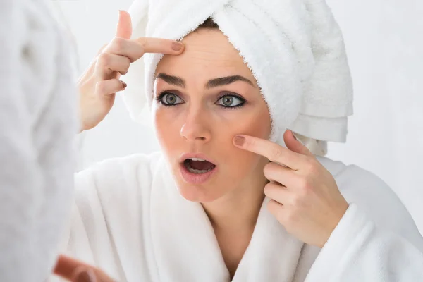 Frau blickt auf Pickel — Stockfoto