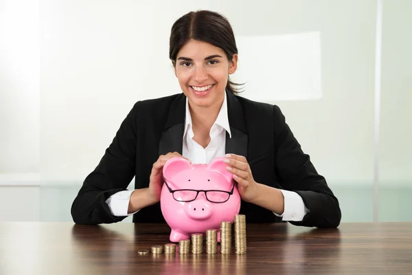 Mujer de negocios con Piggybank y monedas — Foto de Stock