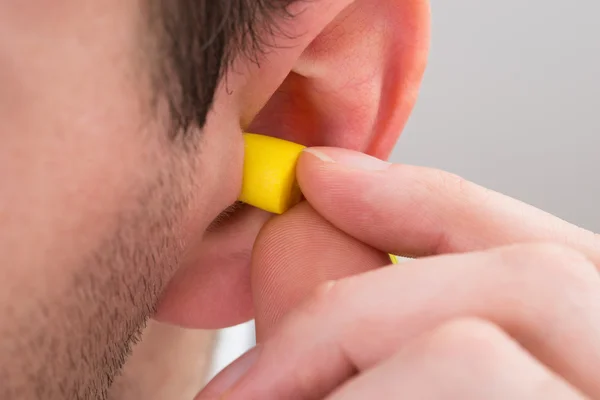 Fone de ouvido amarelo na orelha — Fotografia de Stock