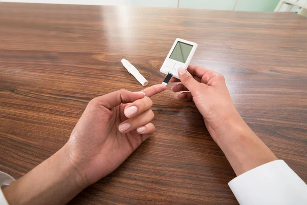 Patiënt handen met Glucometer — Stockfoto