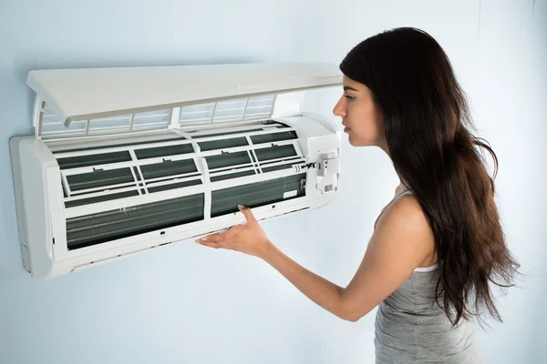 Vrouw controleren airconditioner — Stockfoto