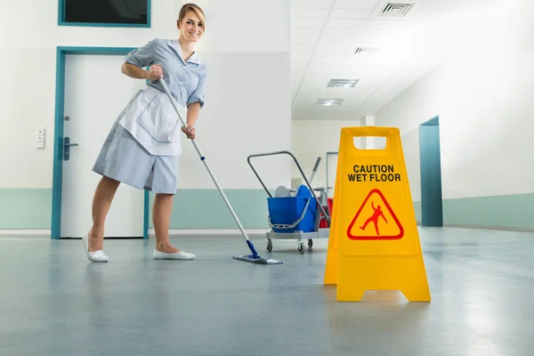 Janitor e piso molhado sinal — Fotografia de Stock