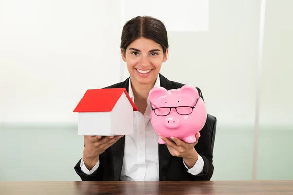 Affärskvinna med hus och Piggybank — Stockfoto