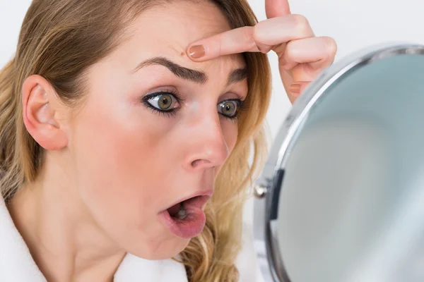 Mujer mirando espinilla — Foto de Stock