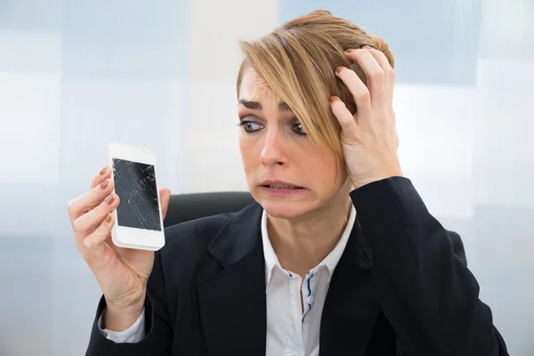 Бізнес-леді тримає зламаний смартфон — стокове фото
