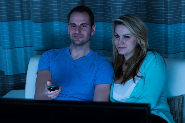 Para na kanapie oglądając telewizor — Zdjęcie stockowe