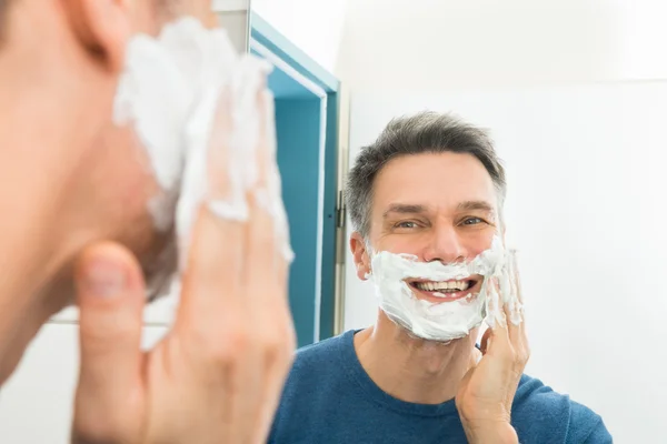 Hombre aplicando crema de afeitar — Foto de Stock