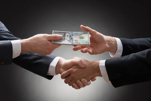 Empresários apertando as mãos e recebendo dinheiro — Fotografia de Stock