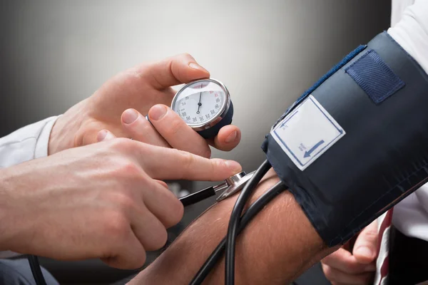 Médico verificando a pressão arterial — Fotografia de Stock