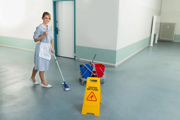 Vrouwelijke Janitor schoonmaken verdieping — Stockfoto