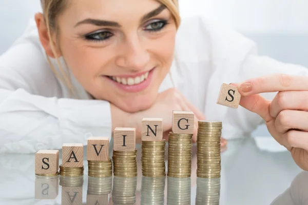 Affärskvinna med besparingar block på mynt — Stockfoto
