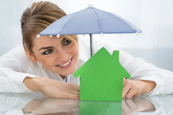 Geschäftsfrau mit Haus und Regenschirm — Stockfoto