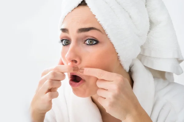 Vrouw kijken naar puistje — Stockfoto