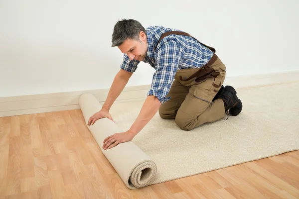 Worker Unrolling Carpet — Stock Photo, Image