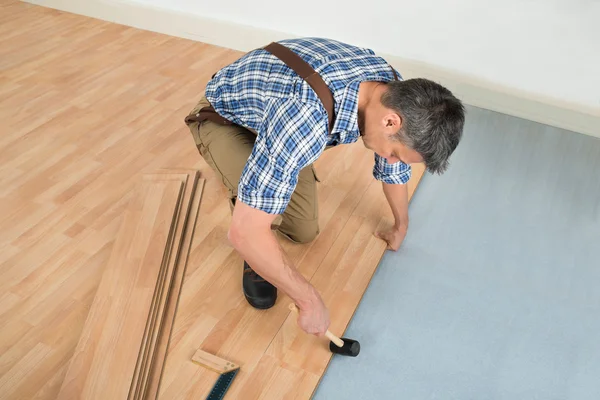 Trabajador montaje piso laminado —  Fotos de Stock