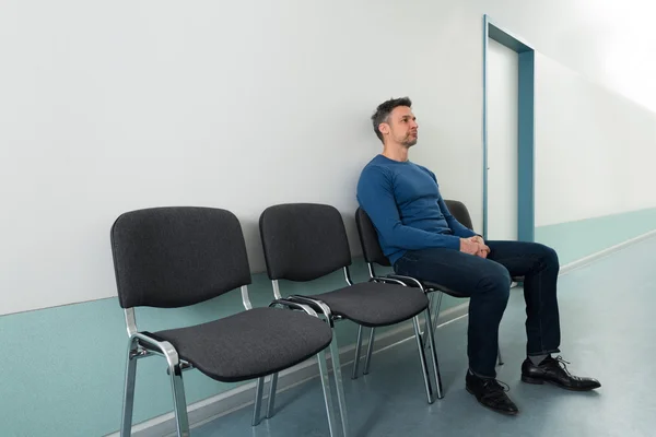 Man sitter på stol på sjukhus — Stockfoto