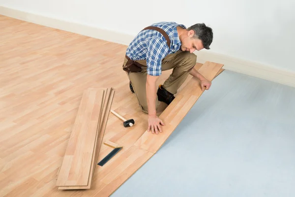 Carpinteiro Instalando piso laminado — Fotografia de Stock