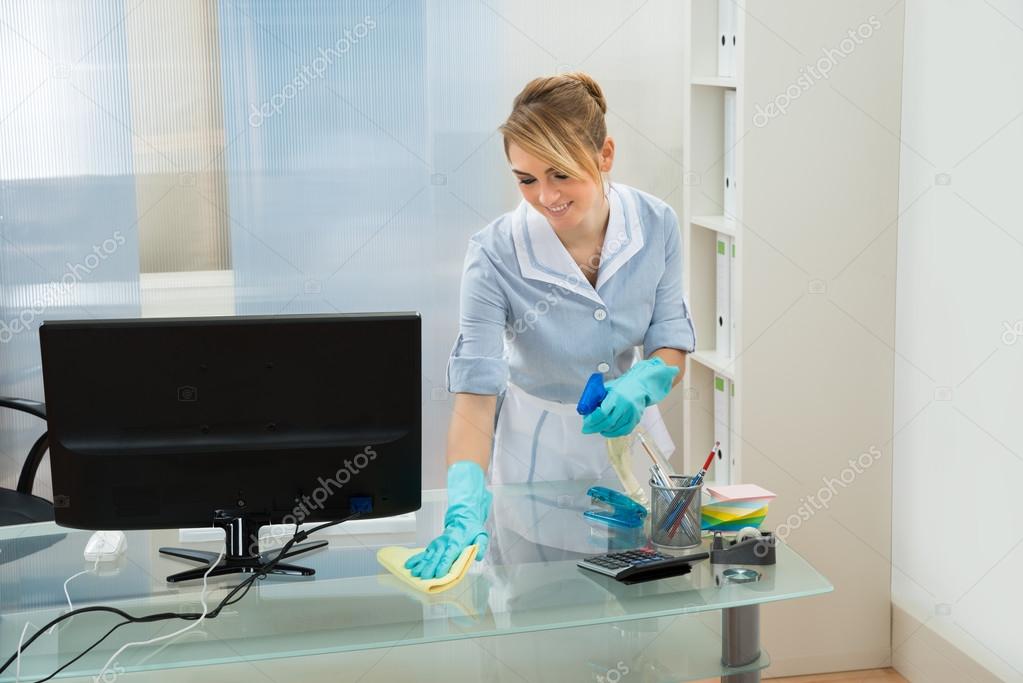 Maid Cleaning Desk With Feather Duster — Stock Photo © AndreyPopov