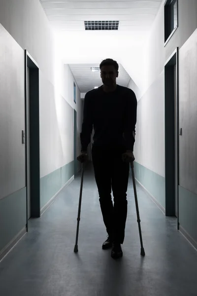 Hombre caminando con muletas — Foto de Stock