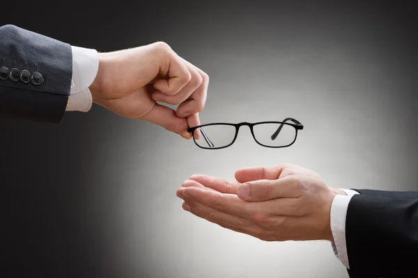 Biznesmen dając oczu okulary — Zdjęcie stockowe