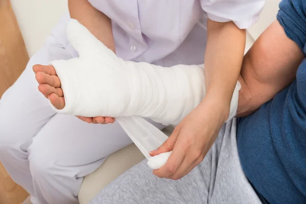 Krankenschwester kleidet geduldige Hand — Stockfoto