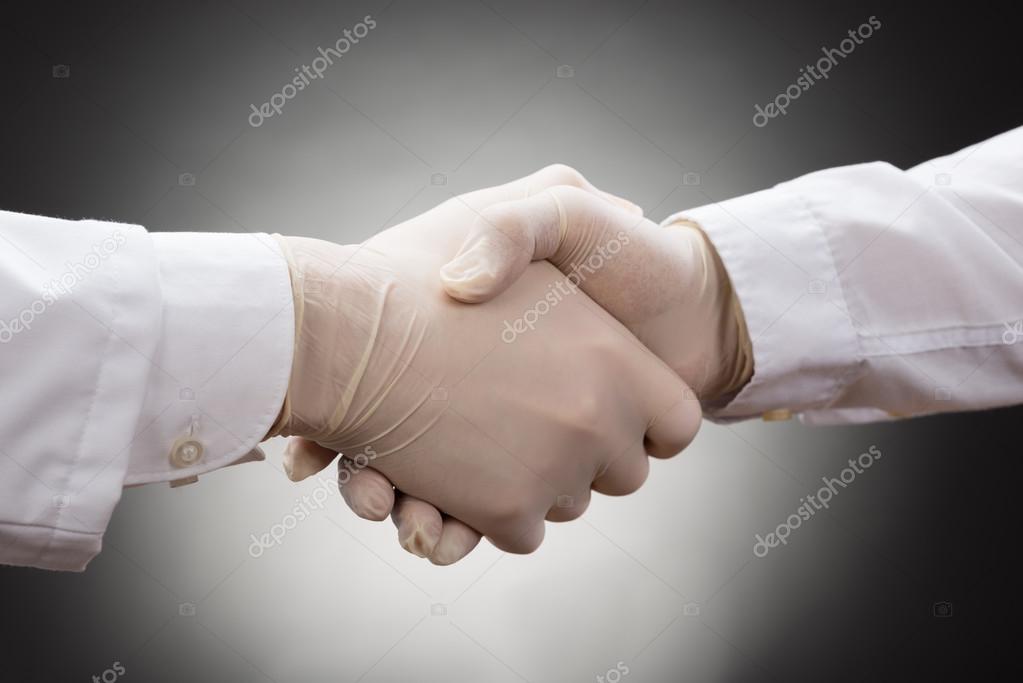 Doctors in Gloves Shaking Hands — Stock Photo © AndreyPopov 74130815