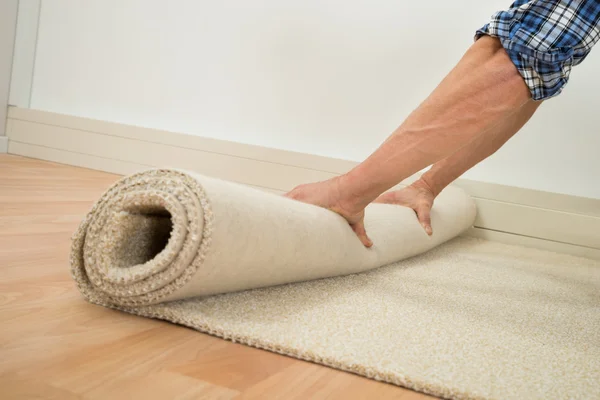 Worker Folding Carpet On Floor — Stock Photo, Image