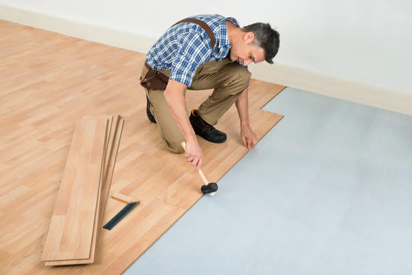 Carpinteiro Instalando piso laminado — Fotografia de Stock