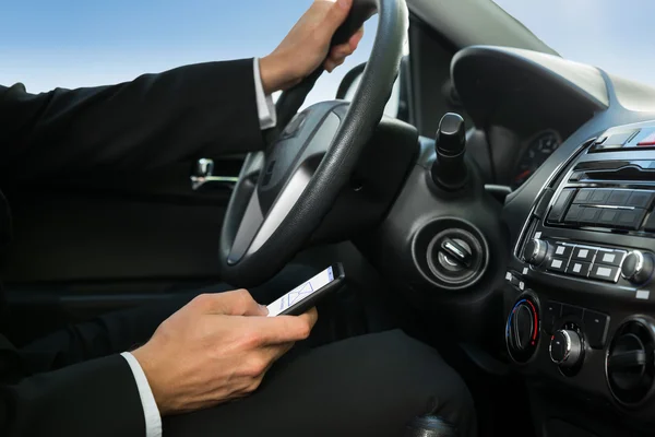 Hombre mensajes de texto mientras conduce coche — Foto de Stock